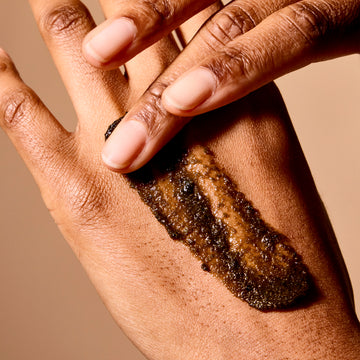 Woman hands applying body scrub